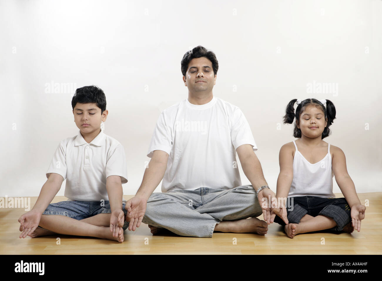 Mann mit seinen Kindern Yoga zu praktizieren Stockfoto