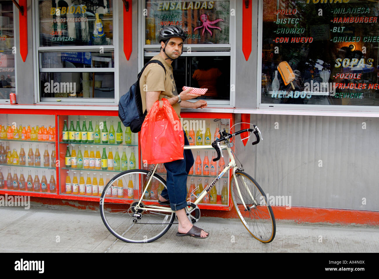 Ein Mann auf einem Fahrrad hält für einen Hot Dog zu einem nehmen Sie Platz in Lower Manhattan. Stockfoto