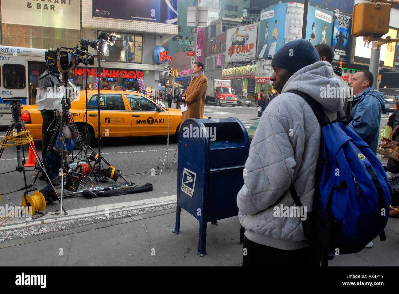 Ein Reporter von Fox News ist eine live-Übertragung auf dem Times Square als Passant watch Stockfoto