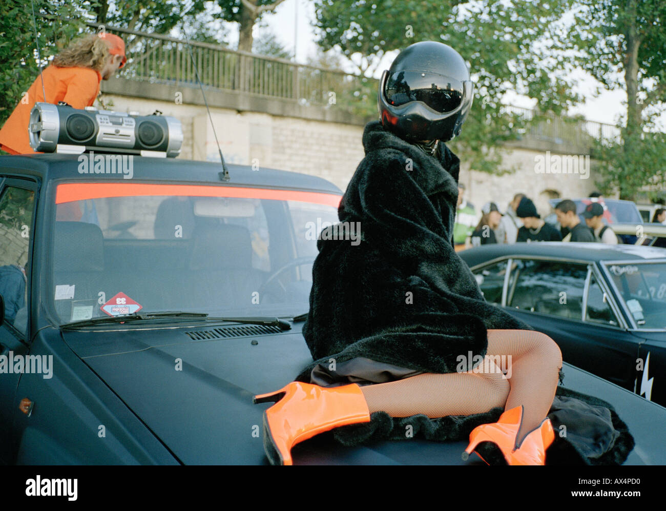 Eine Frau posiert auf eine Motorhaube Stockfoto