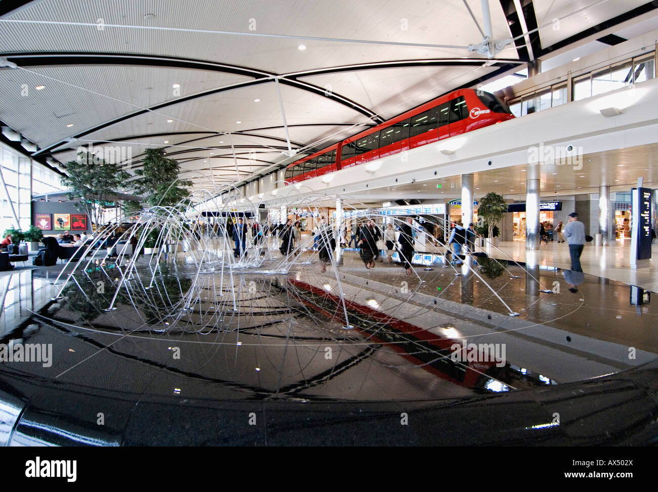 Obenliegende Straßenbahn Wasserspiel und Fußgänger in McNamara Terminal des Flughafen Detroit Detroit Michigan Stockfoto