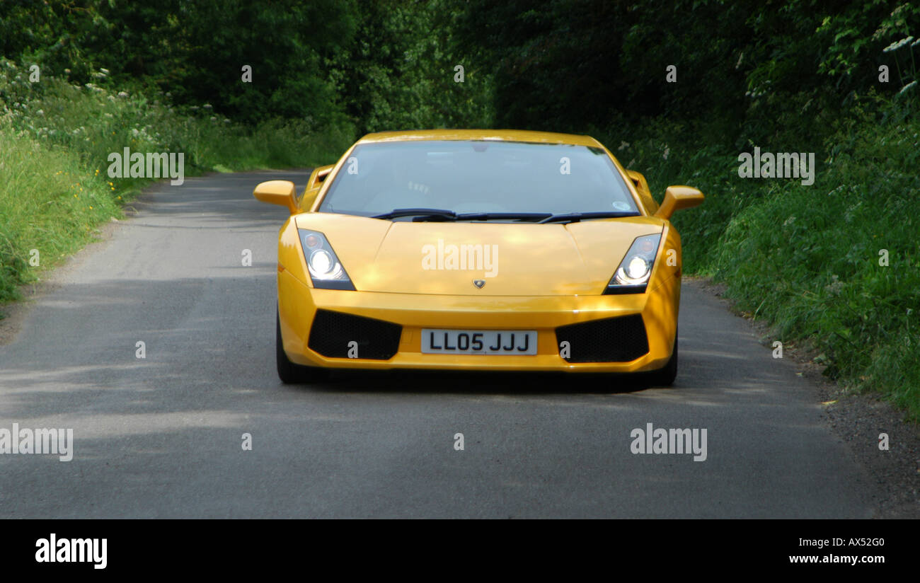 Gelbe Lamborghini Gallardo Sportwagen entlang einer Straße in der englischen Landschaft zu beschleunigen Stockfoto