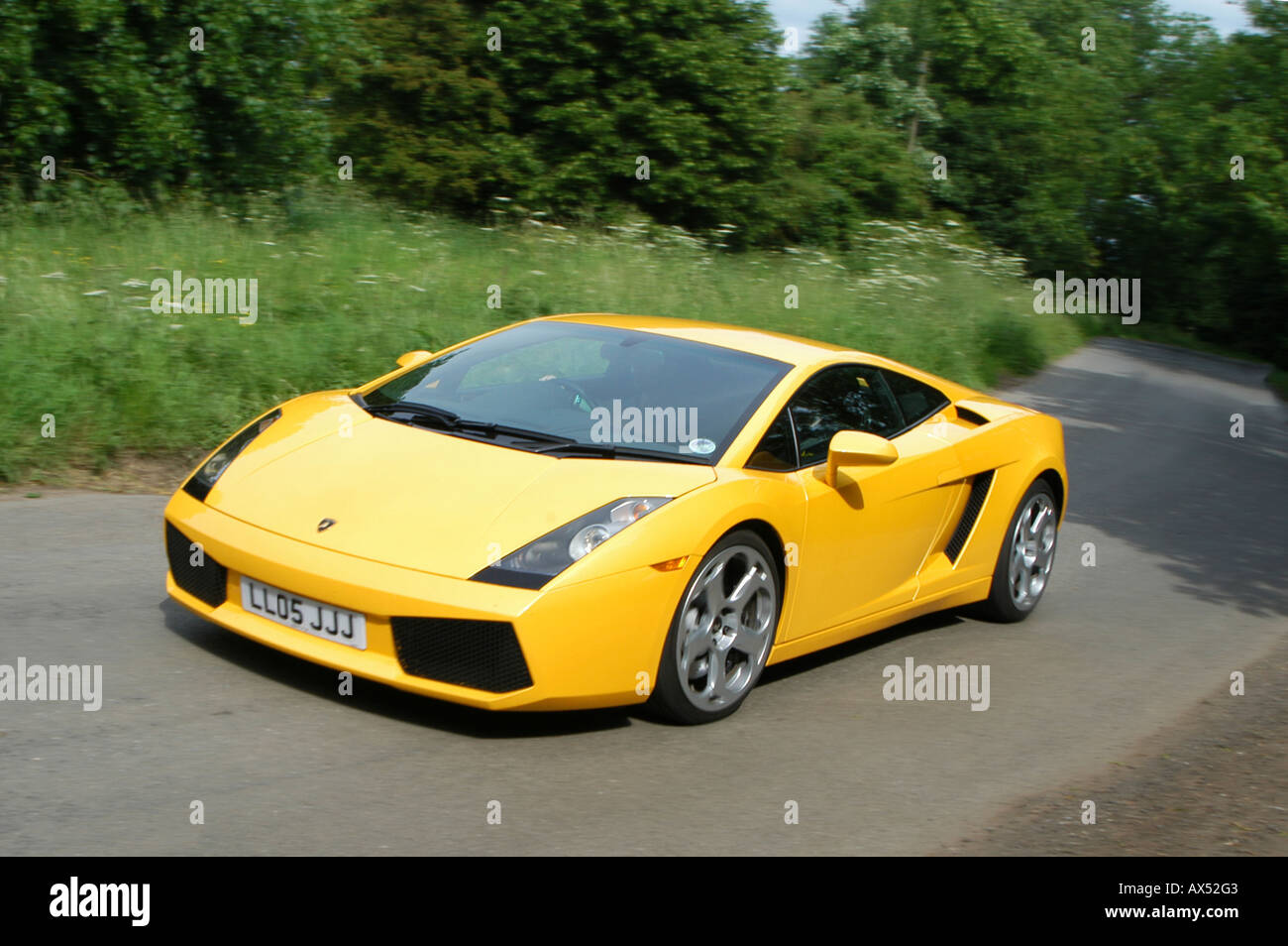 Gelbe Lamborghini Gallardo Sportwagen entlang einer Straße in der englischen Landschaft zu beschleunigen Stockfoto