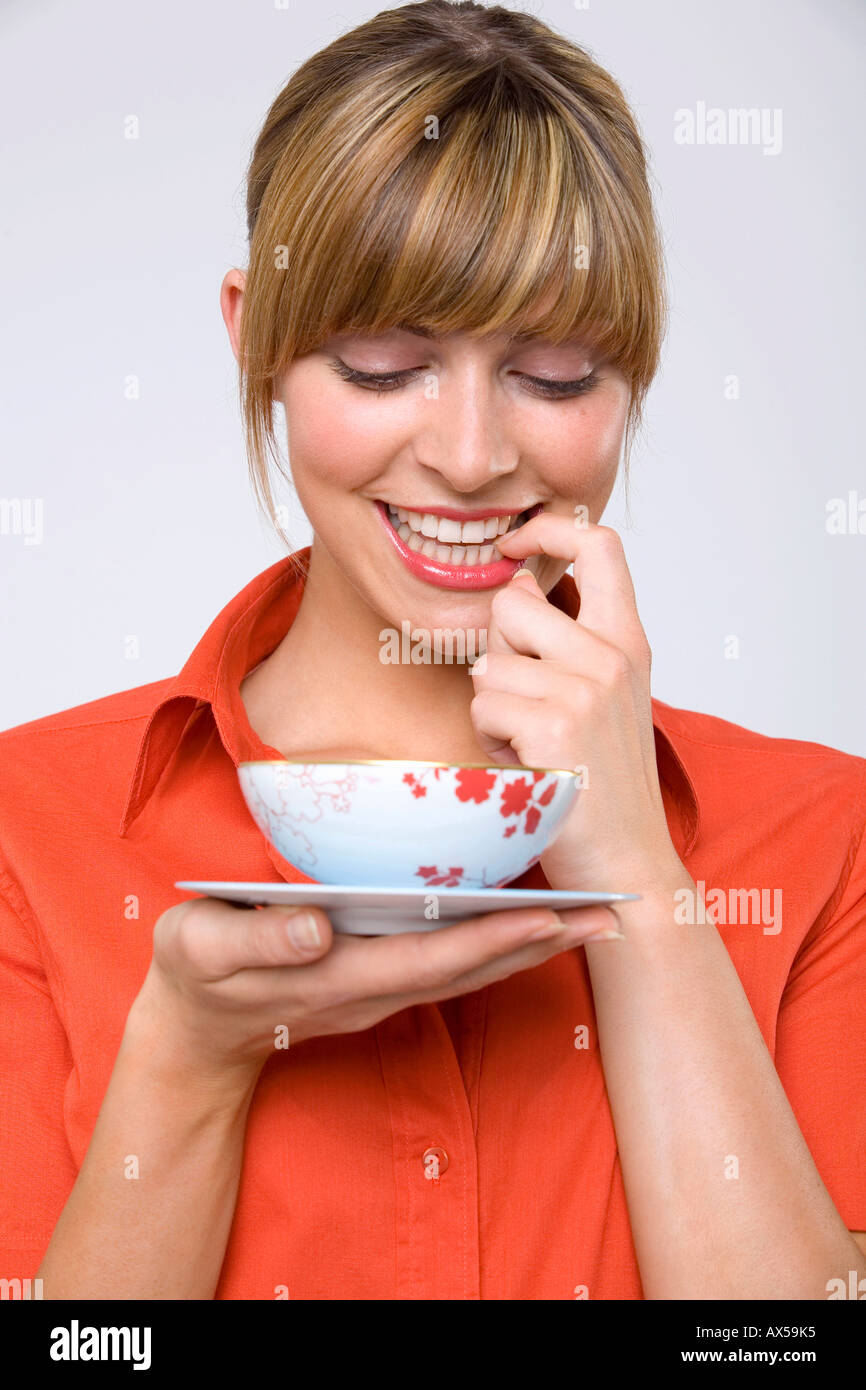 Junge Frau hält Teeschale, blickte, Nahaufnahme Stockfoto