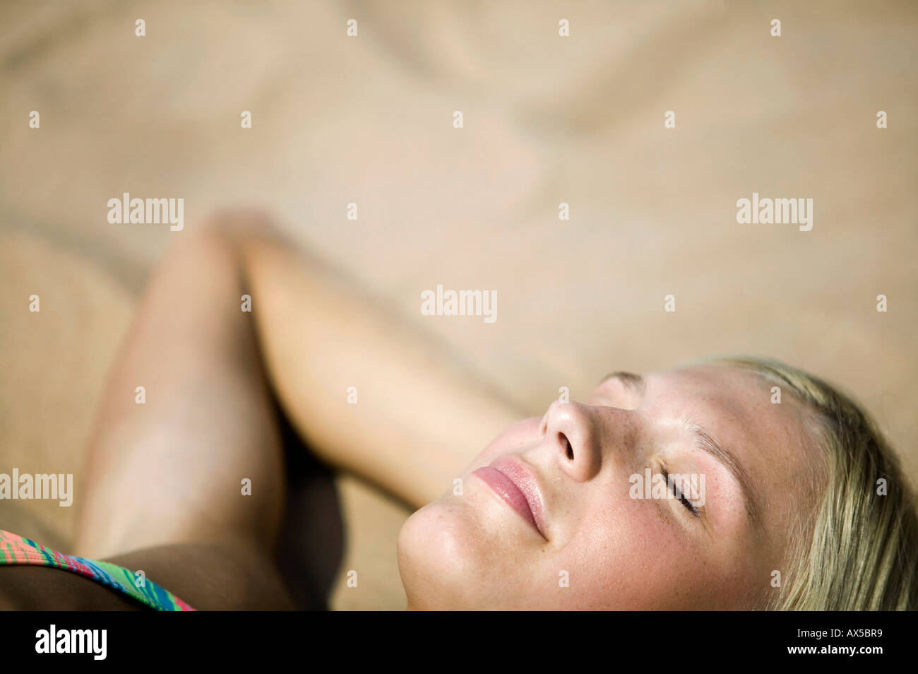 Frau entspannen am Strand, Augen geschlossen, (Fokus auf Vordergrund) Stockfoto