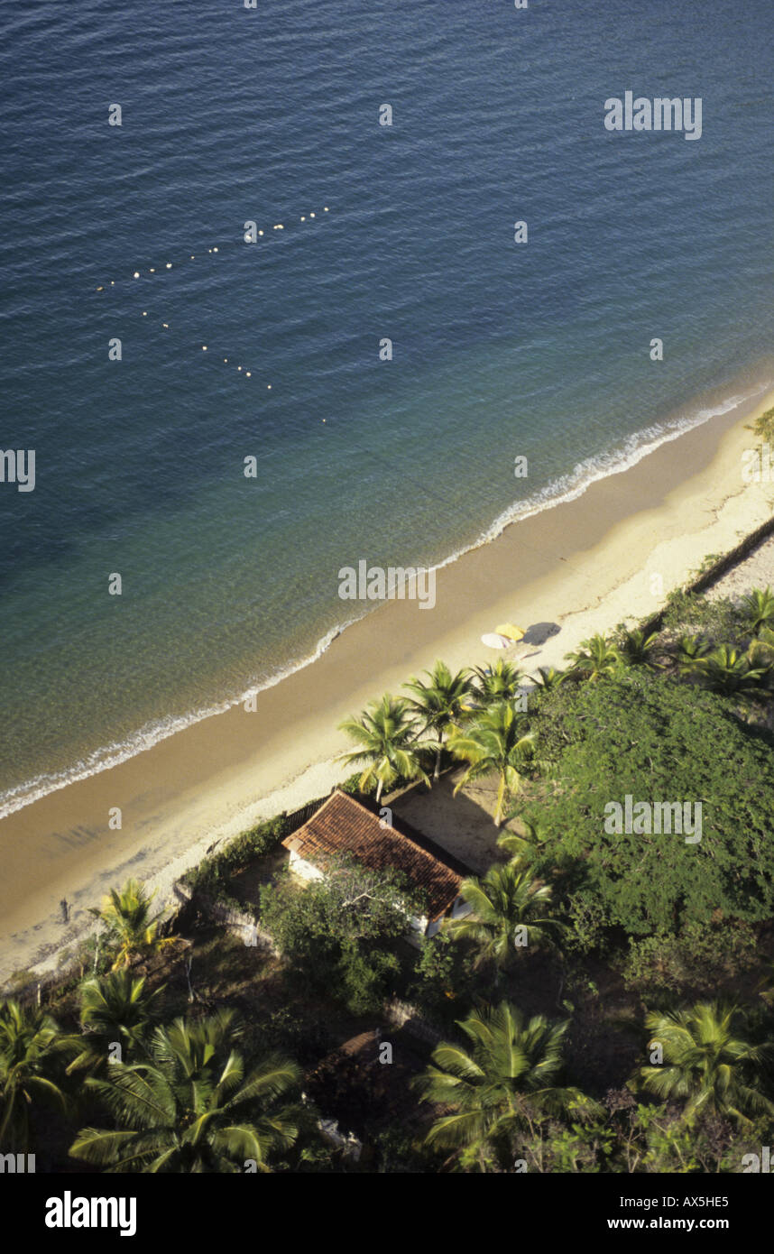 Ilha Grande, Brasilien. Luftbild des Hauses auf dem sandigen Strand, umgeben von Palmen mit Marker Floats. Stockfoto