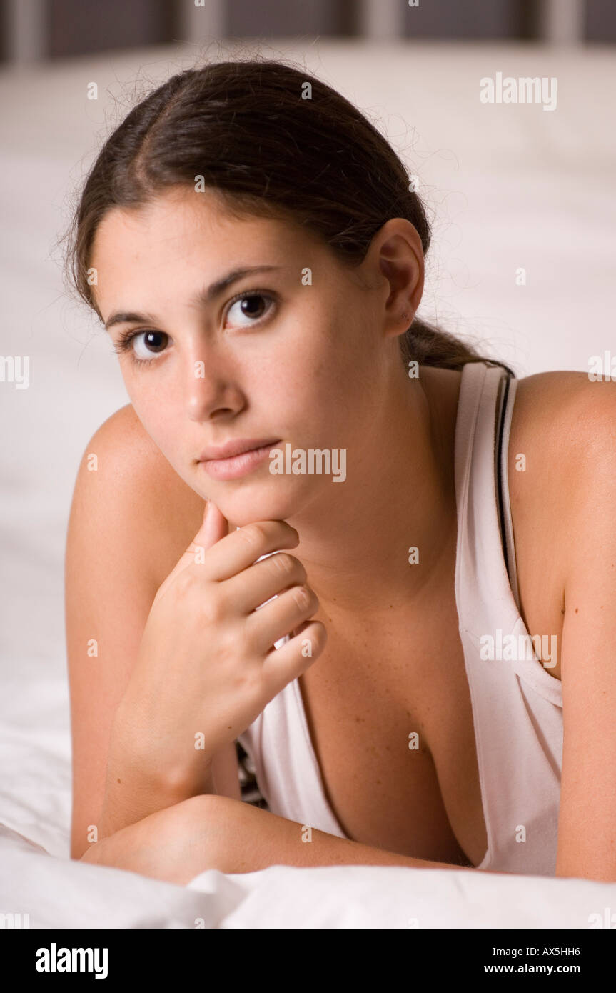 Eine natürlich schöne junge Frau auf einem Bett liegend Stockfoto