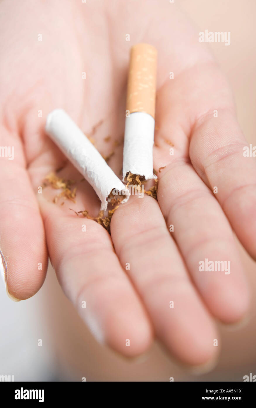 Hand hält eine Zigarette in Hälfte gebrochen Stockfoto
