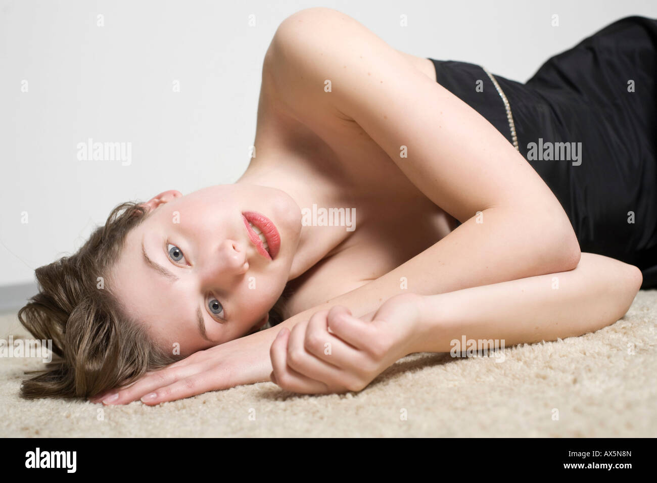 Porträt einer jungen Frau, die auf dem Teppich Verlegen Stockfoto