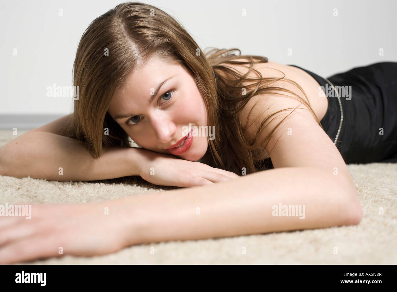 Porträt einer jungen Frau, die auf dem Teppich Verlegen Stockfoto