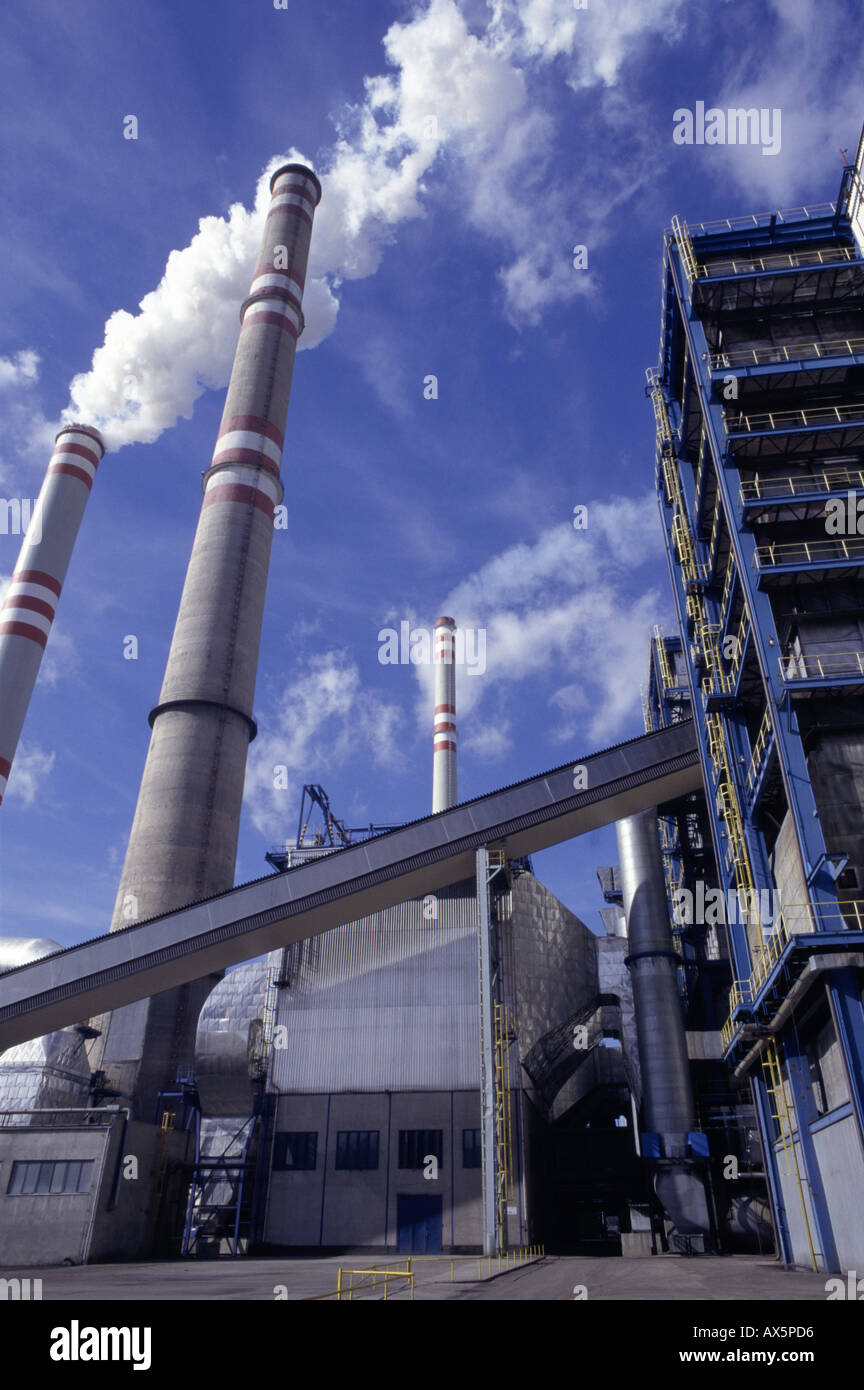 Pocerady, Tschechische Republik. Kraftwerk mit rauchenden Schornsteinen vor blauem Himmel mit weißen Wolken. Stockfoto