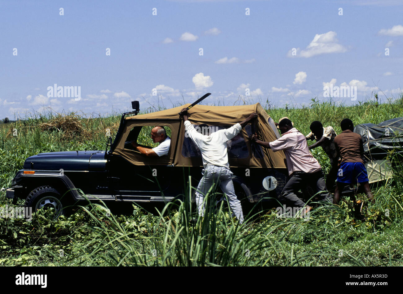 Chipundu, Sambia. Vier-Rad fahren Jeep und Anhänger benötigen einen Stoß aus dem Schlamm "Cross Country" in einem Sumpf zu entkommen. Stockfoto