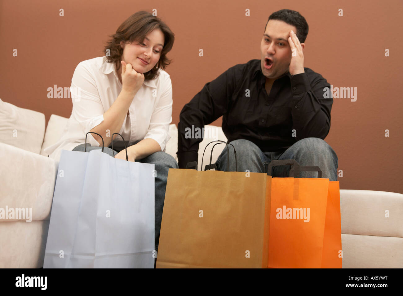 Mann schockiert über seine Frau Einkäufe Stockfoto