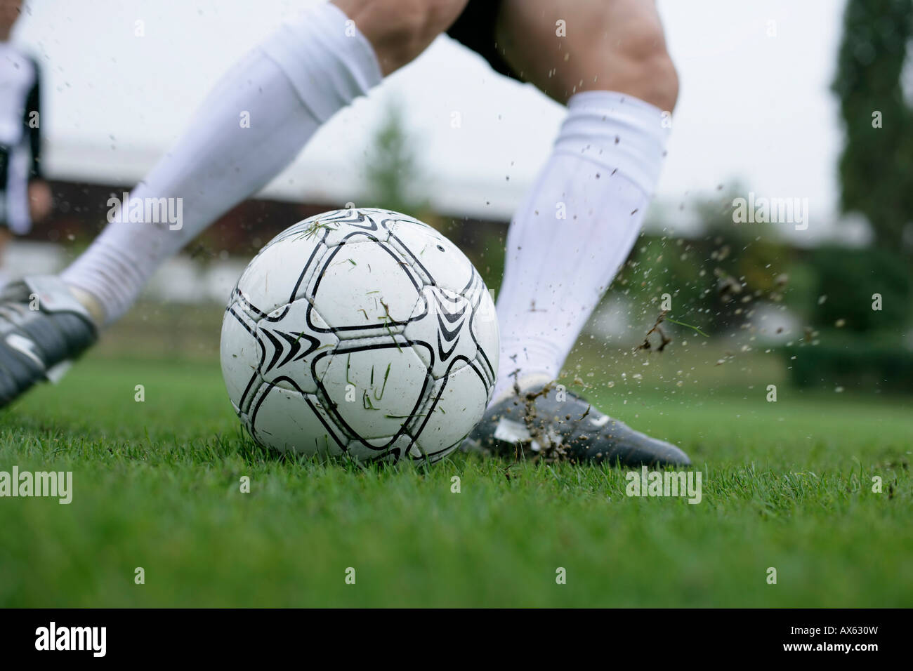 Fußball-Spieler treten einen Fußball Stockfoto