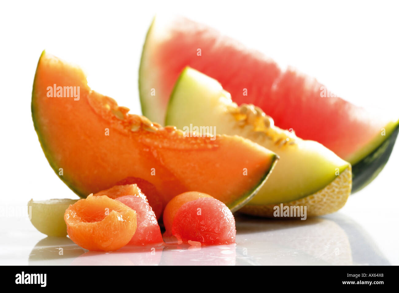 Melonenkugeln und geschnittenen Melonen Stockfoto