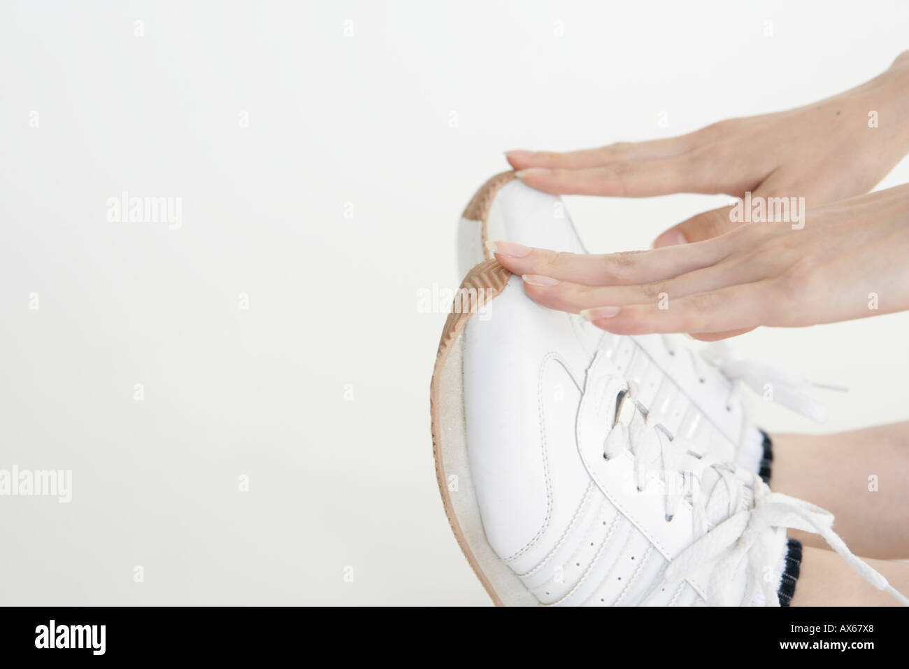 Seitenansicht des weißen Sports Schuhe von einer Frau berührt wird Stockfoto