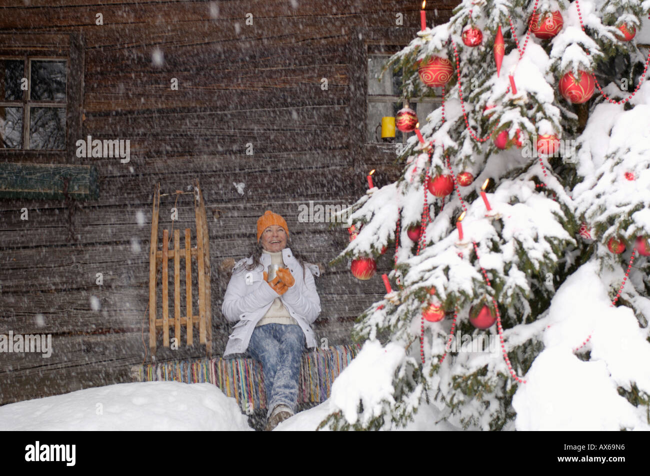 Junge Frau, die am Weihnachtsbaum, Lächeln Stockfoto