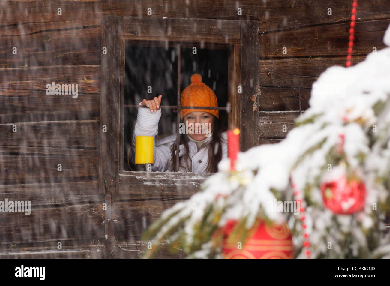 Junge Frau, die am Weihnachtsbaum, Lächeln Stockfoto