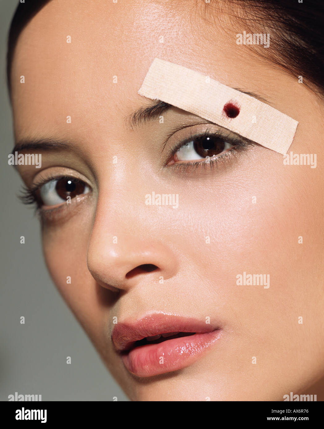Frau mit Pflaster auf ihre Augenbrauen Stockfotografie - Alamy