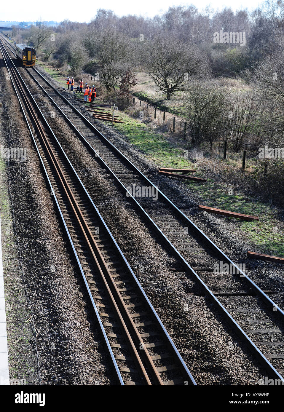 Wartung der Eisenbahner Schwellen auf der Schiene, zu ersetzen, wenn sich ein Zug nähert Stockfoto