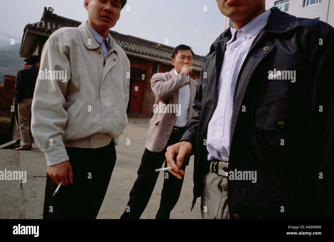Chinesische Männer außerhalb der Ta Gou-Schule in Shaolin Zigaretten rauchen Stockfoto