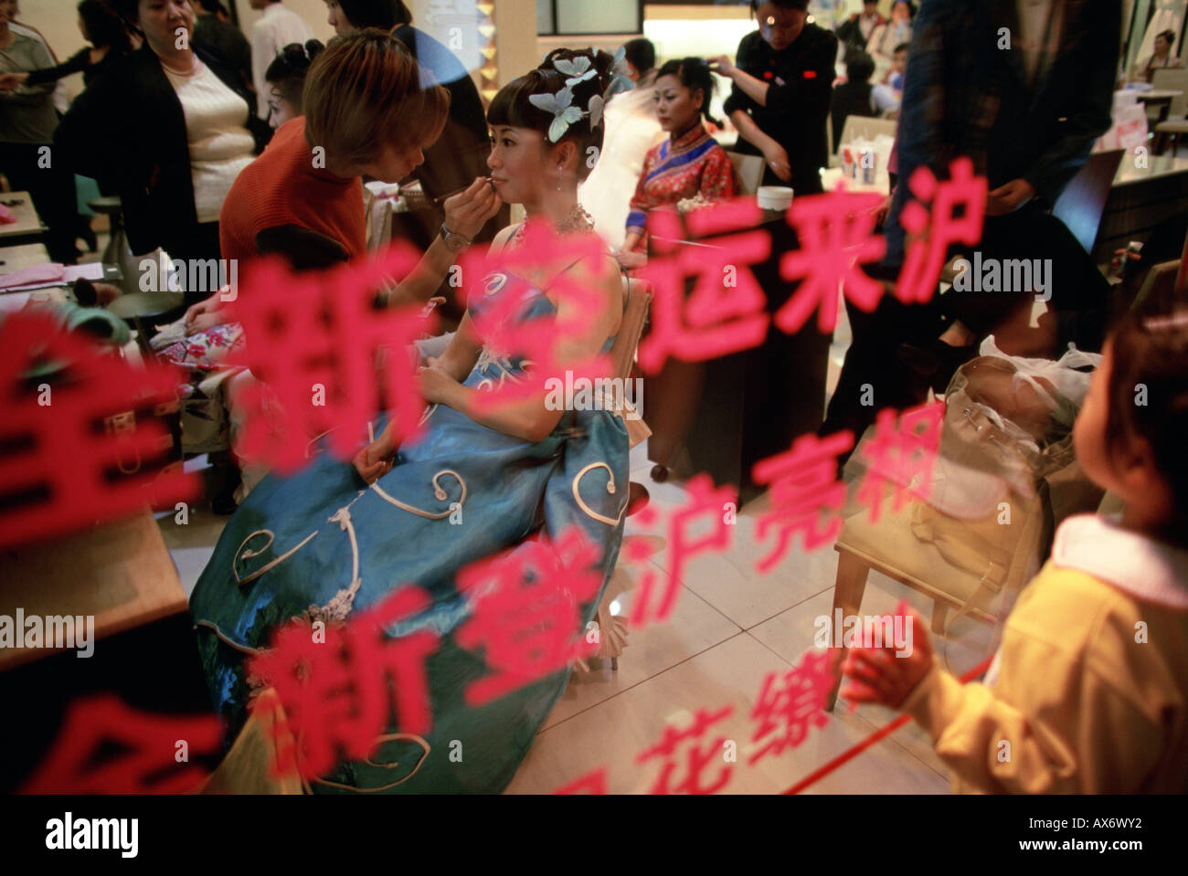 Eine Braut und Bräutigam bekommen ihr Haar und Make-up gemacht bei Hochzeit Fotostudio auf Hua Hai Lu In Shanghai Stockfoto