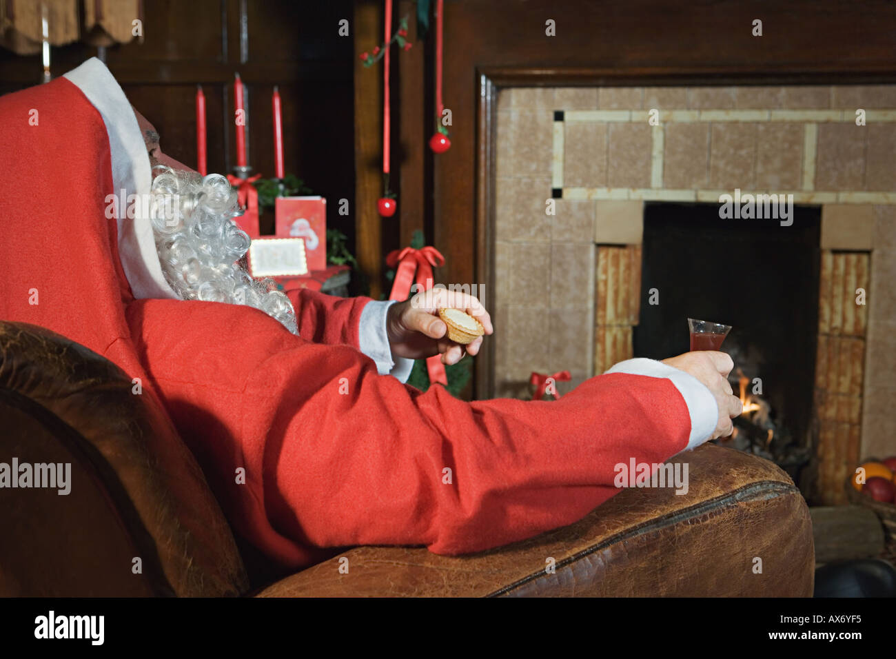 Santa Claus ruht am Kamin Stockfoto
