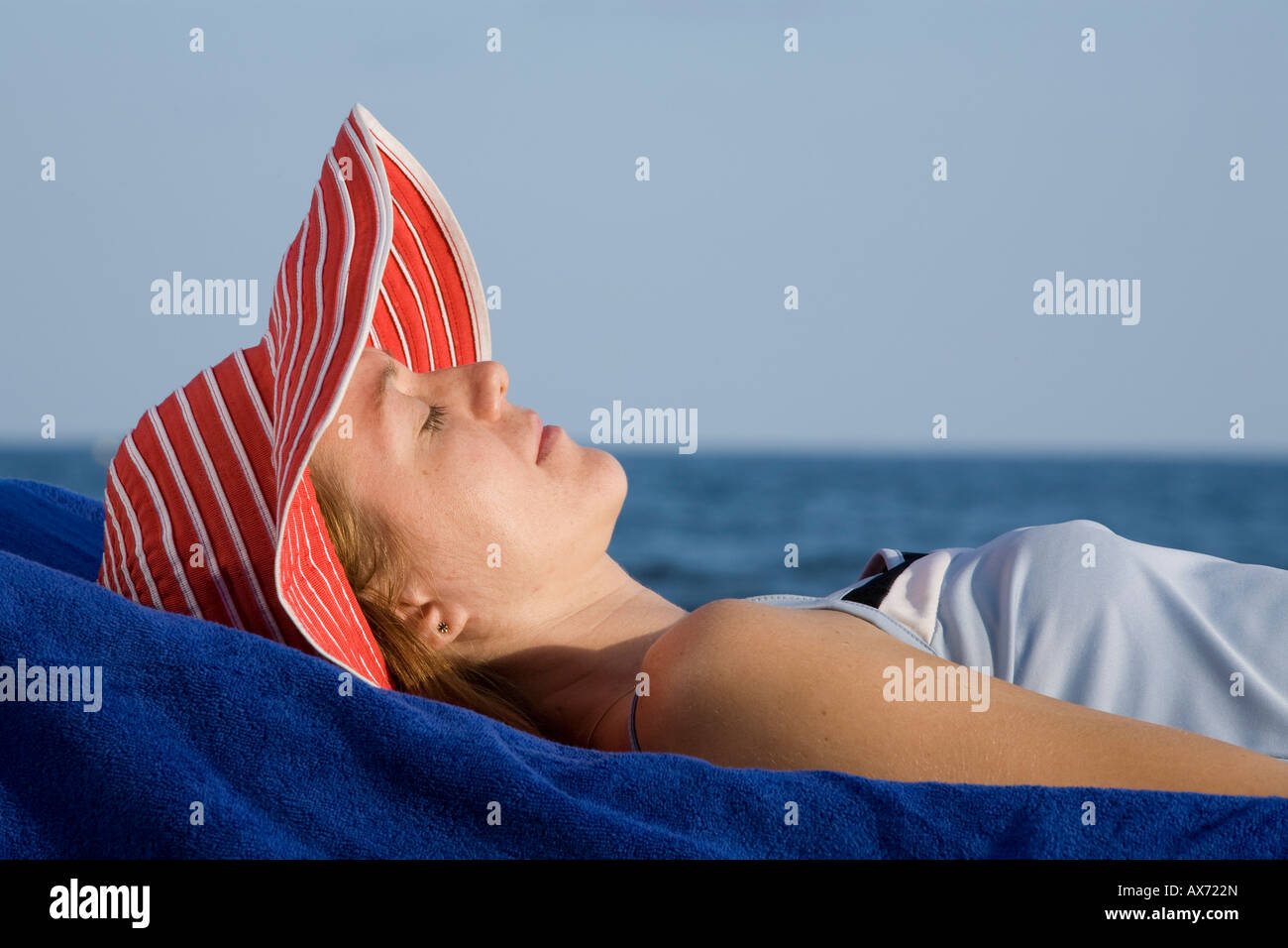 Frau mit Hut, am Strand liegen Stockfoto
