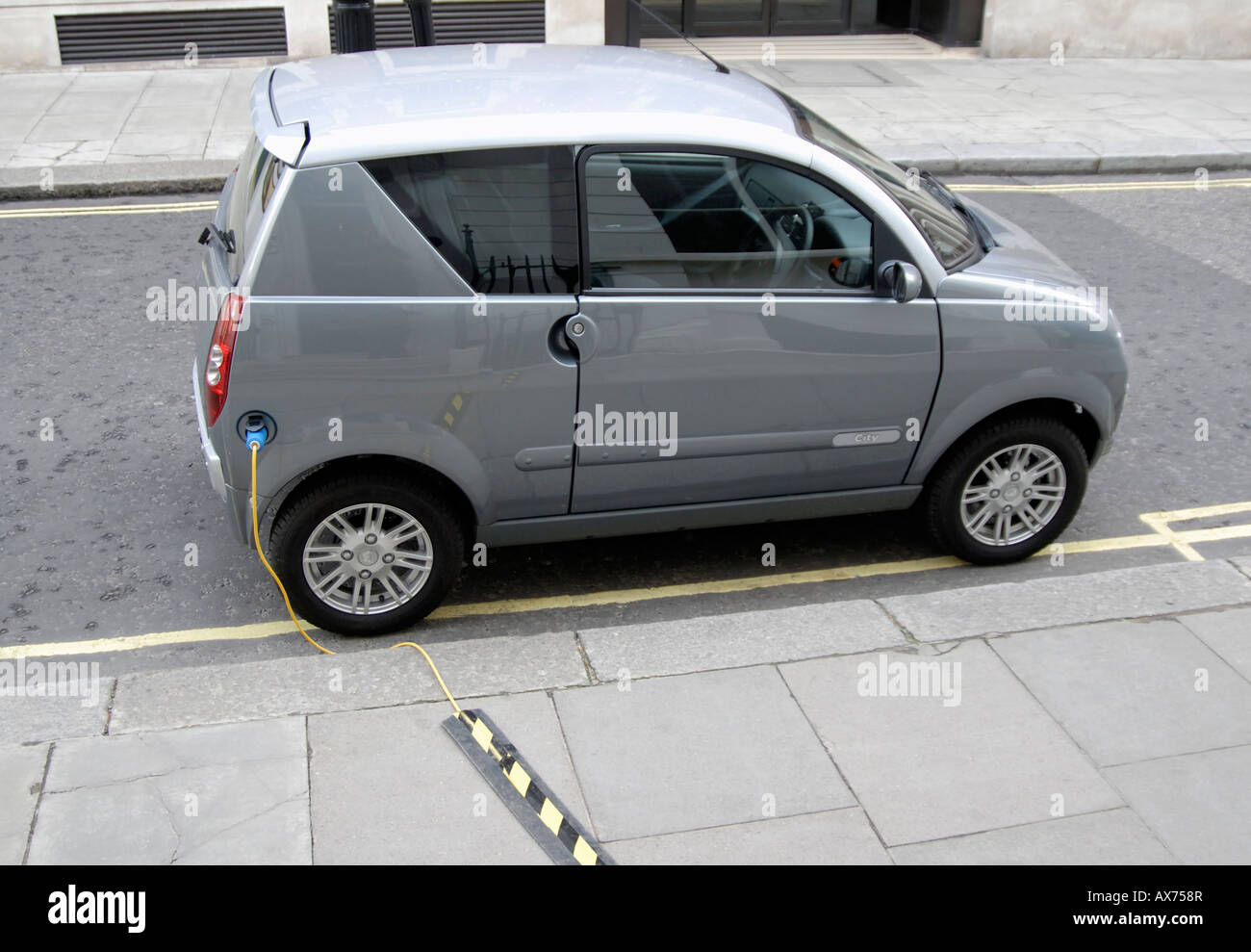 Elektro-Auto eingesteckt zum Aufladen auf Straße (Queen Anne Tor), City of Westminster, London SW1, Wettsektor Stockfoto
