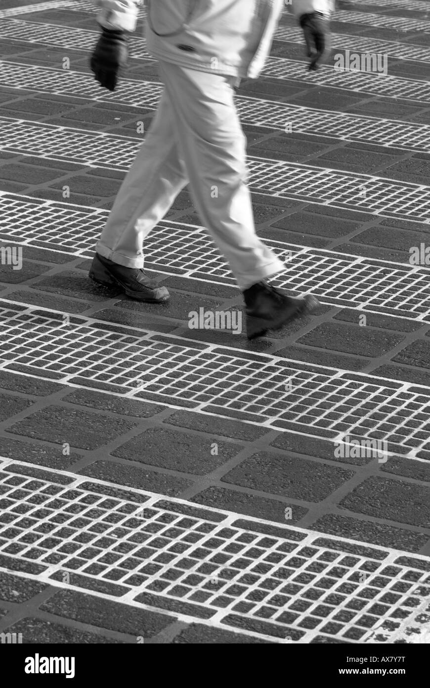 Ein Mann geht über eine grafische Fußgänger Gehweg-Kreuzung Stockfoto