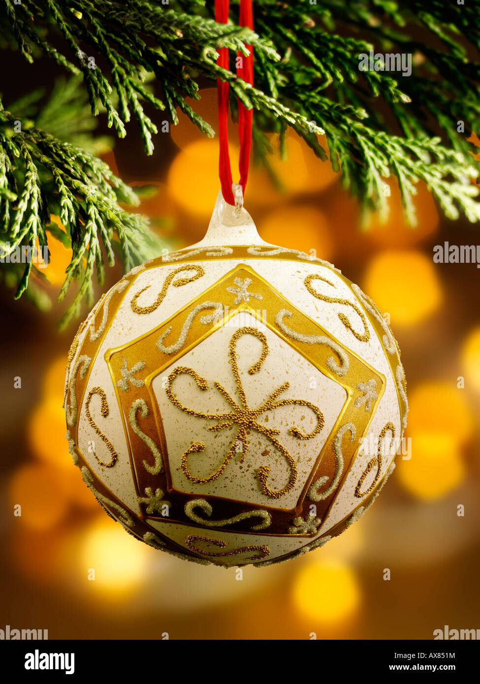 Traditionelle festlich geschmückte Weihnachtskugel, die an einem Weihnachtsbaum hängt Mit Licht dahinter Stockfoto