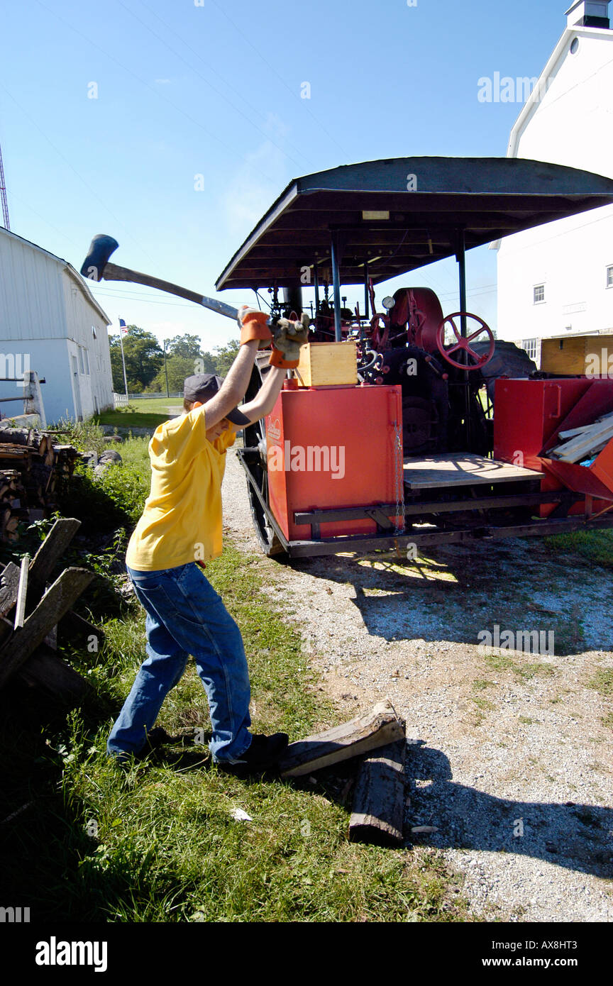 Teenager teilt Holzscheite für den Einsatz in laufen einen Dampfantrieb Traktor Stockfoto