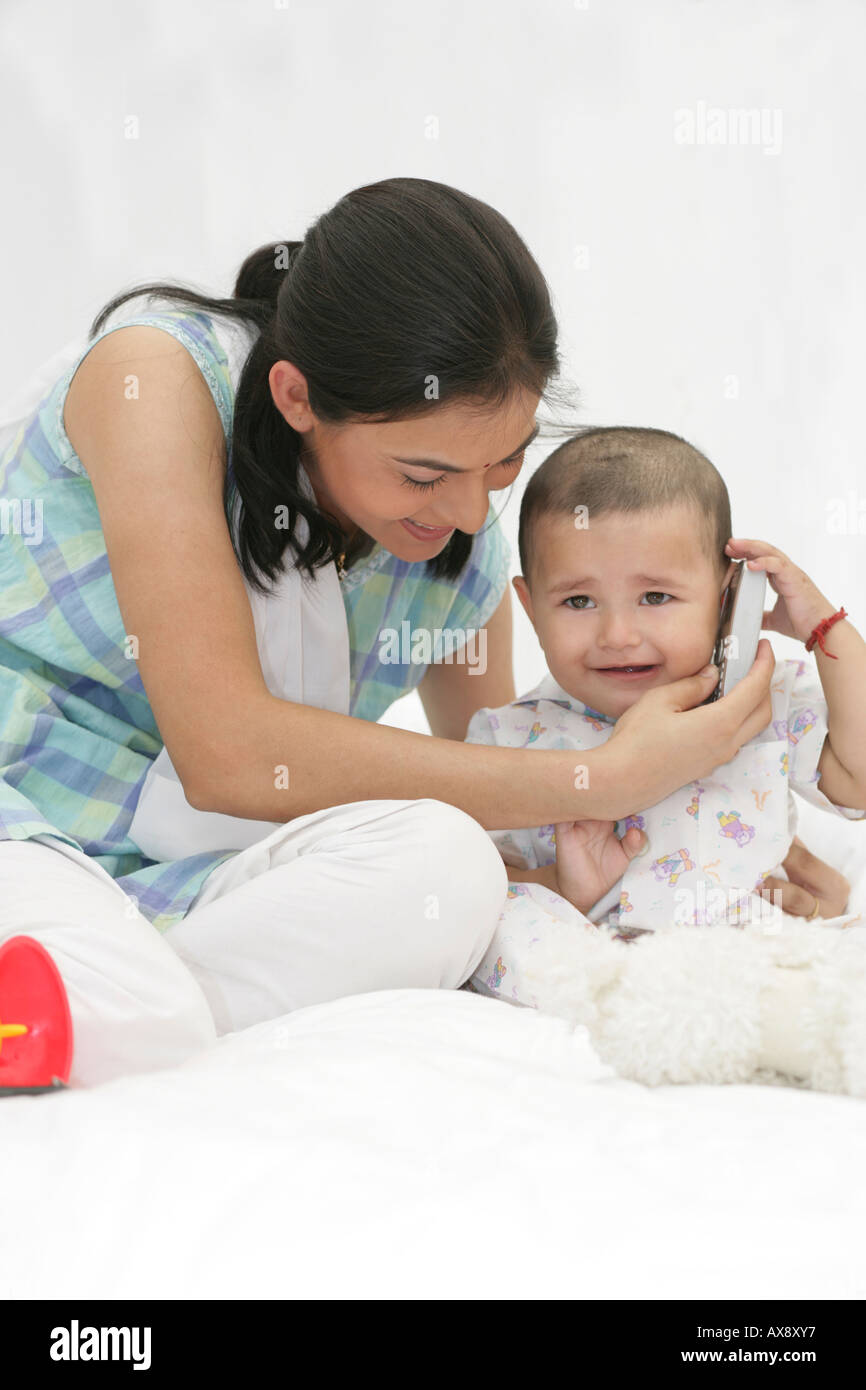 Mutter mit ihrem Baby Sohn mit einem Spielzeug-Handy spielen Stockfoto