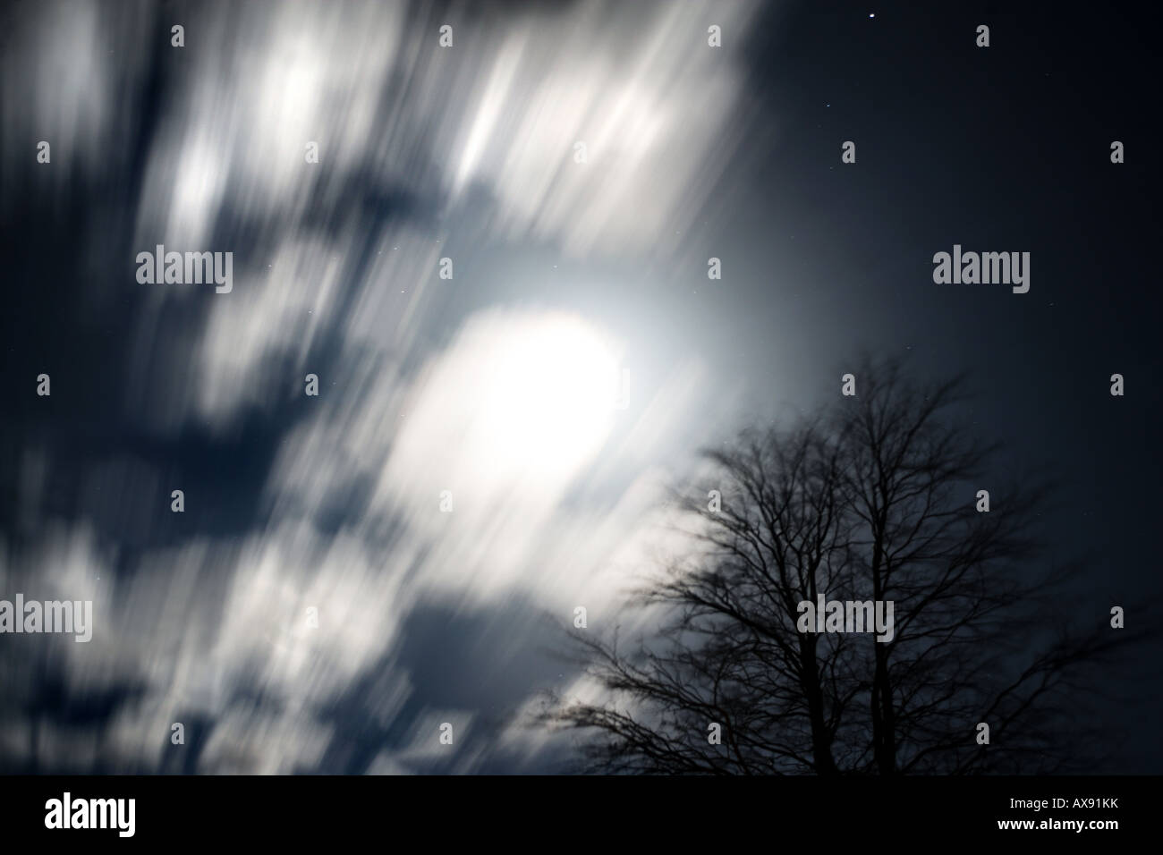 Mond (in der Frühlings-Tagundnachtgleiche) peeping Out hinter schönen Wolken. Bewegung ist die Bewegung der Wolken über längere Exposition Stockfoto