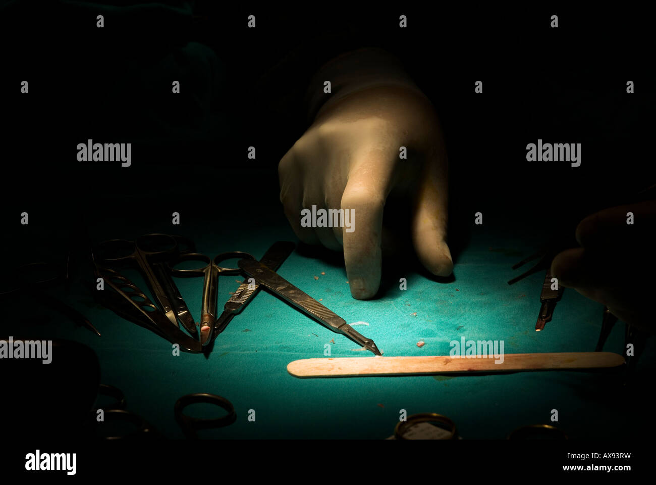 Hand des Chirurgen Handschuhe und chirurgische Instrumente auf sterile grünen Tisch Stockfoto