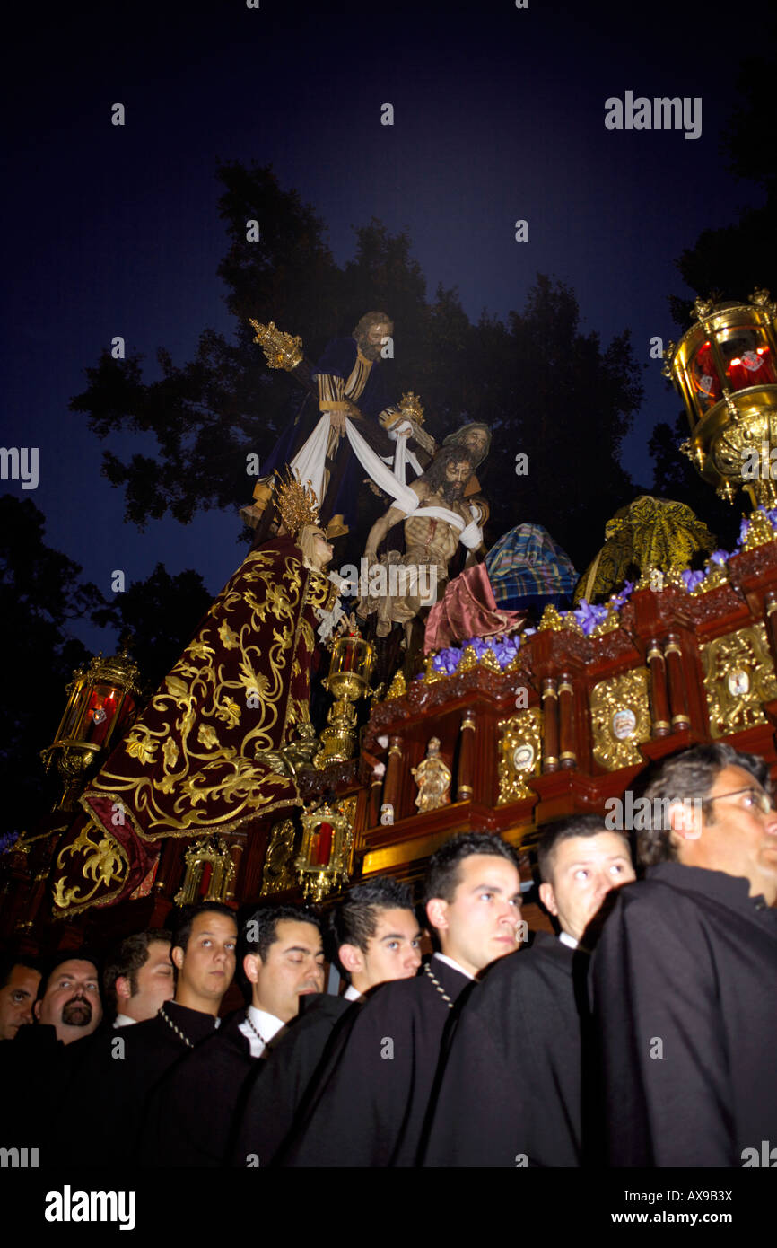 Männer mit der Statue von Jesus Christus am Kreuz durch die Straßen von Malaga, Spanien, Semana Santa Stockfoto
