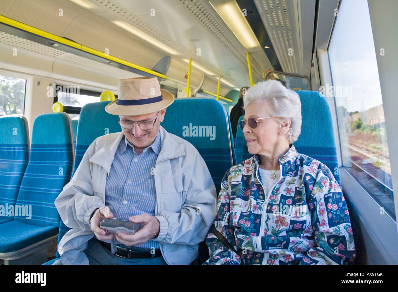 Ein Senioren-Paar auf einen Zug in England, Check-out die Bilder ihrer Digitalkamera Stockfoto