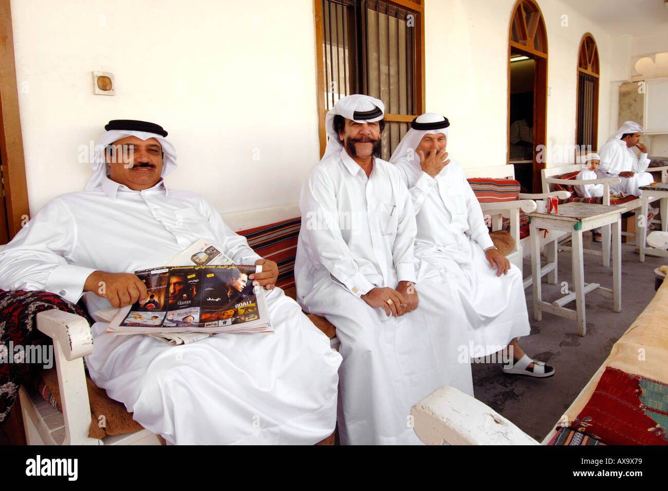 Qataris in traditioneller Kleidung draußen ein Teehaus in Doha, der Hauptstadt von Katar. Stockfoto