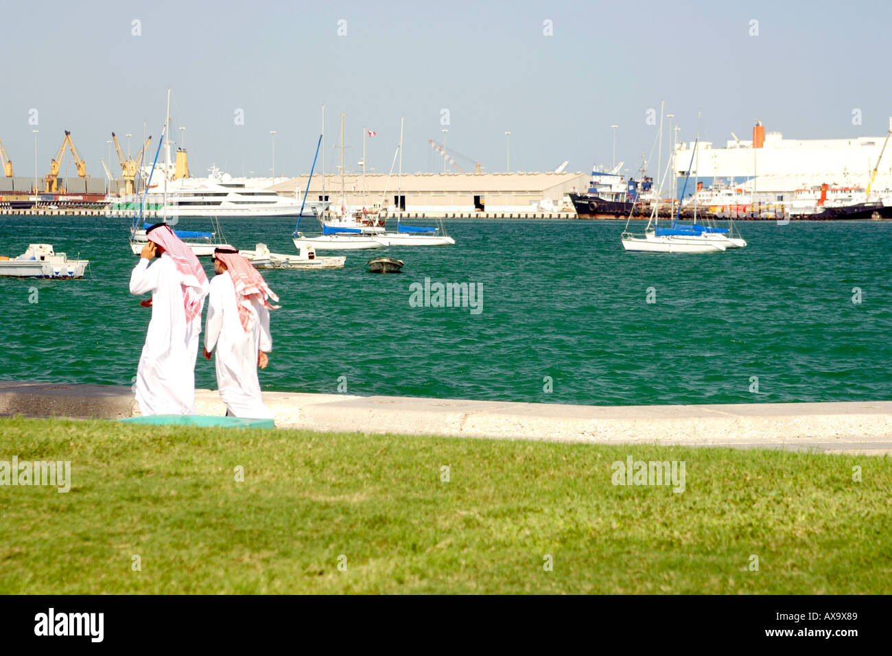 Araber in traditioneller Kleidung zu Fuß entlang der Corniche in Doha, Katar. Stockfoto