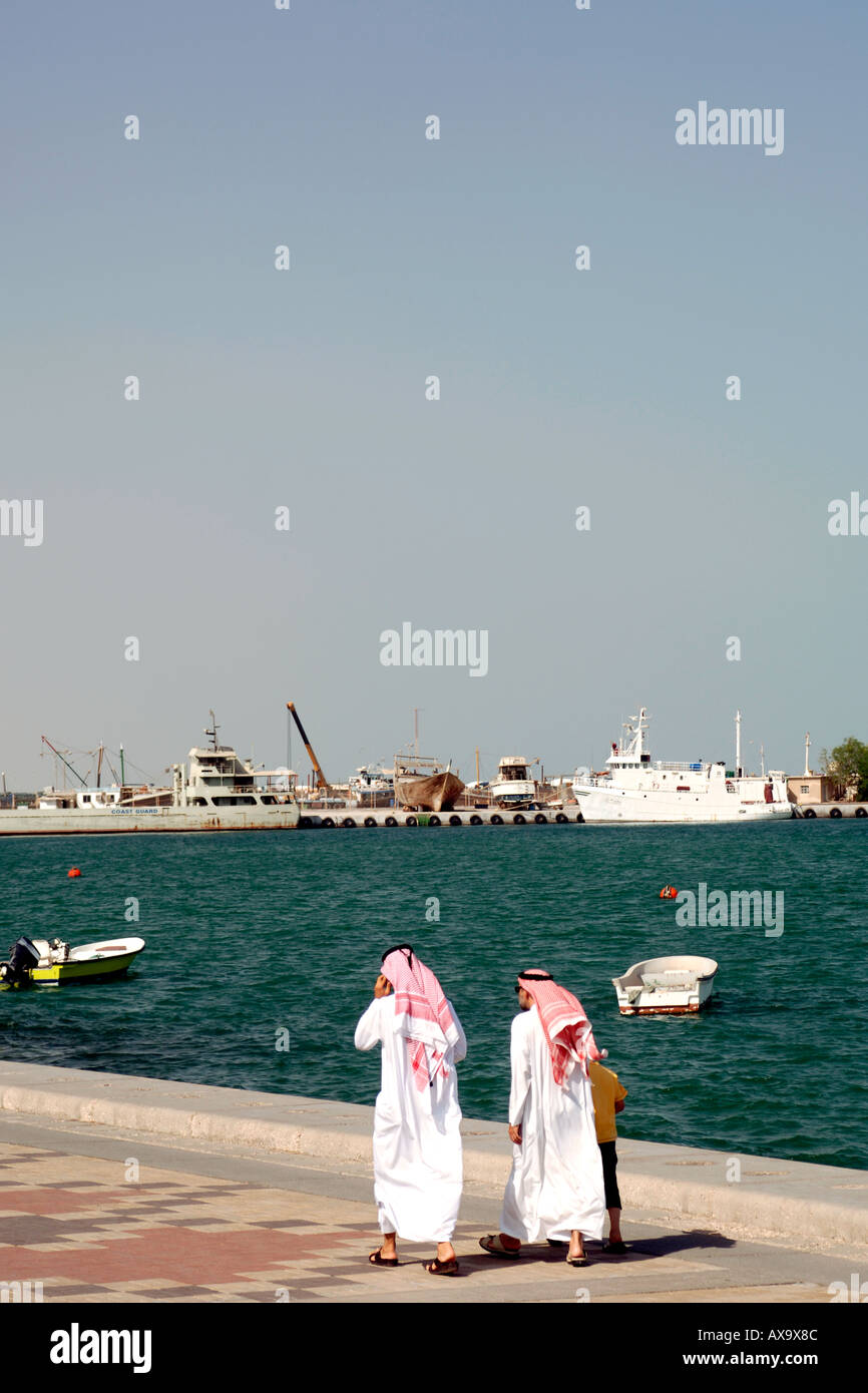 Araber in traditioneller Kleidung zu Fuß entlang der Corniche in Doha, Katar. Stockfoto