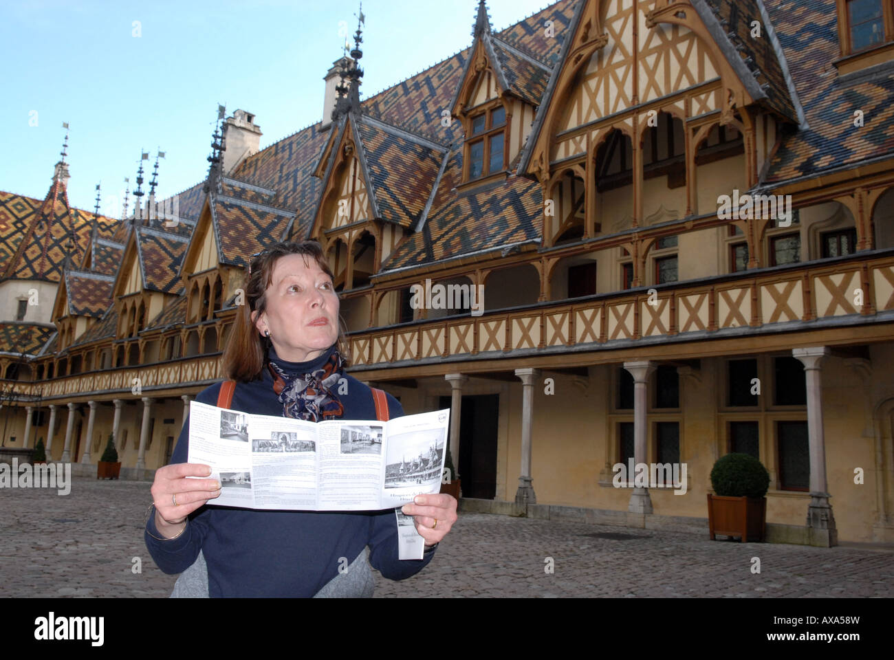 Eine weibliche Touristen Leseleitfaden an Hospices de Beaune, Hotel-Dieu in Beaune, Burgund, Frankreich Stockfoto