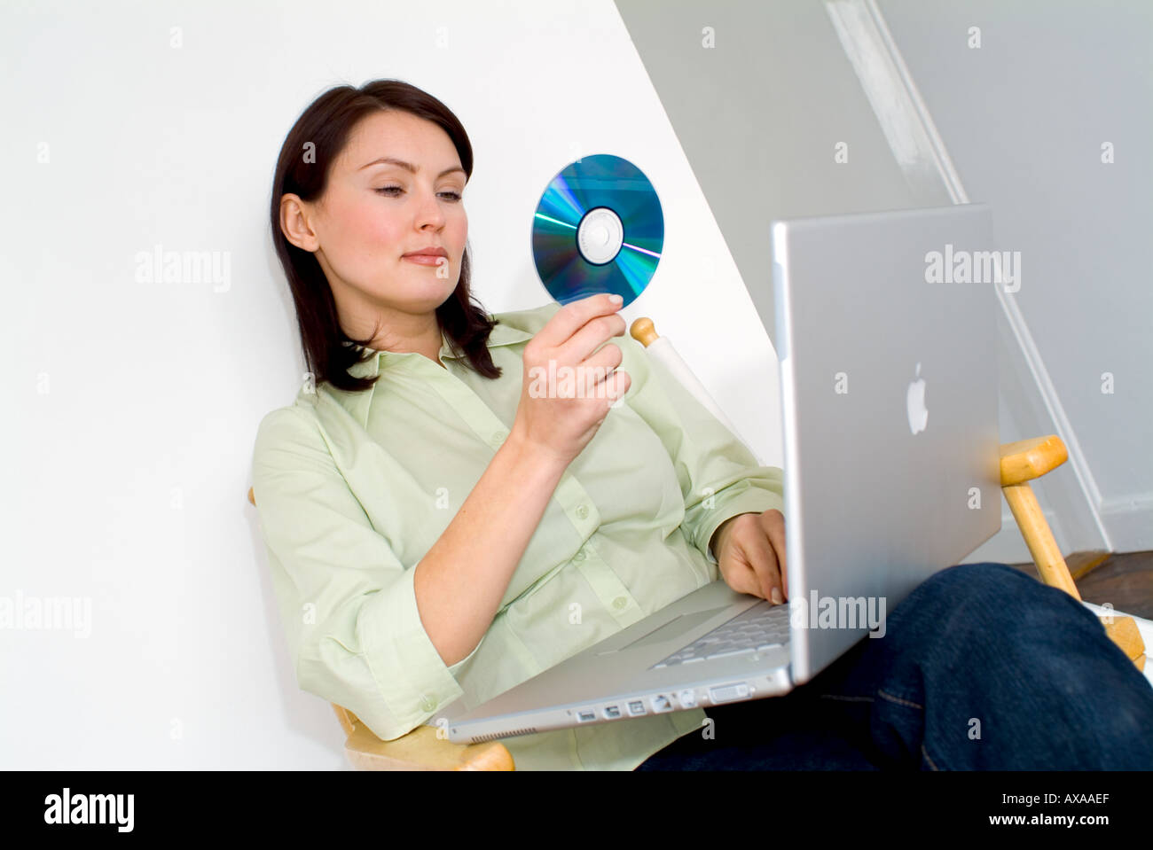 Frau arbeitet an einem Laptop-Computer mit CD Stockfoto
