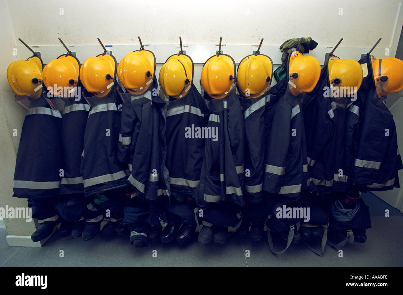 Zeile der Feuerwehr Helme Jacken und Stiefel in einem Bahnhof Haus, Großbritannien UK Stockfoto