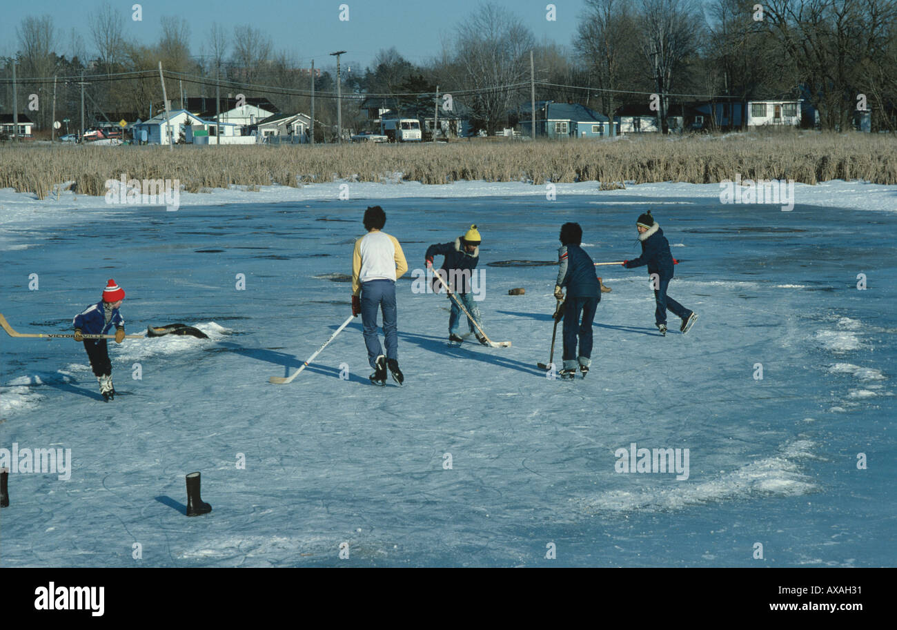 Kinder informellen Spiel des Hockeys auf zugefrorenen Teich im Moorland außerhalb Kingston Ontario in Kanada Stockfoto