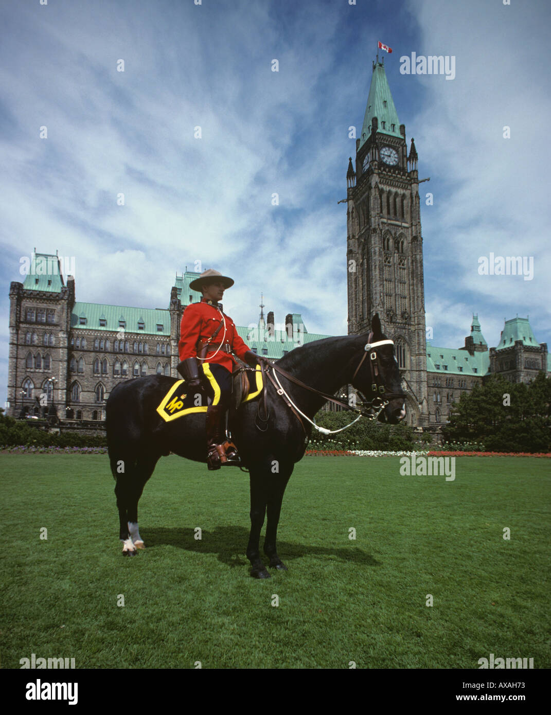 Mountie in roten zeremoniellen uniform auf schwarzes RCMP Pferd auf der Wiese vor dem Parlamentsgebäude in Ottawa Kanada Stockfoto