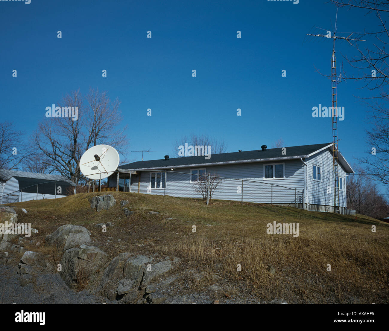 Bescheidenen Haus in ländlichen Ontario mit großen Satelliten Schüssel und hoher TV-mast Stockfoto