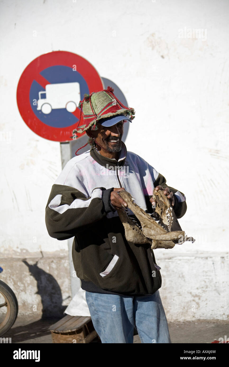 Straße Verkäufer Mann Verkauf von Hai Kiefer in Agadir, Marokko. Er trägt einen Hut und hoodie Stockfoto