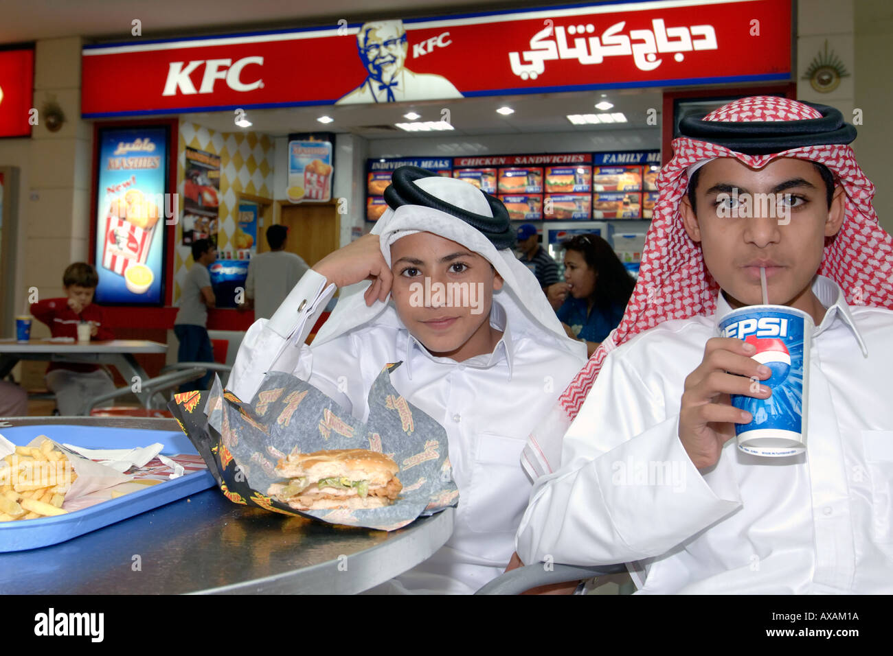 Katar Kinder in traditionellen Outfits Fastfood in einem Einkaufszentrum in Doha. Stockfoto