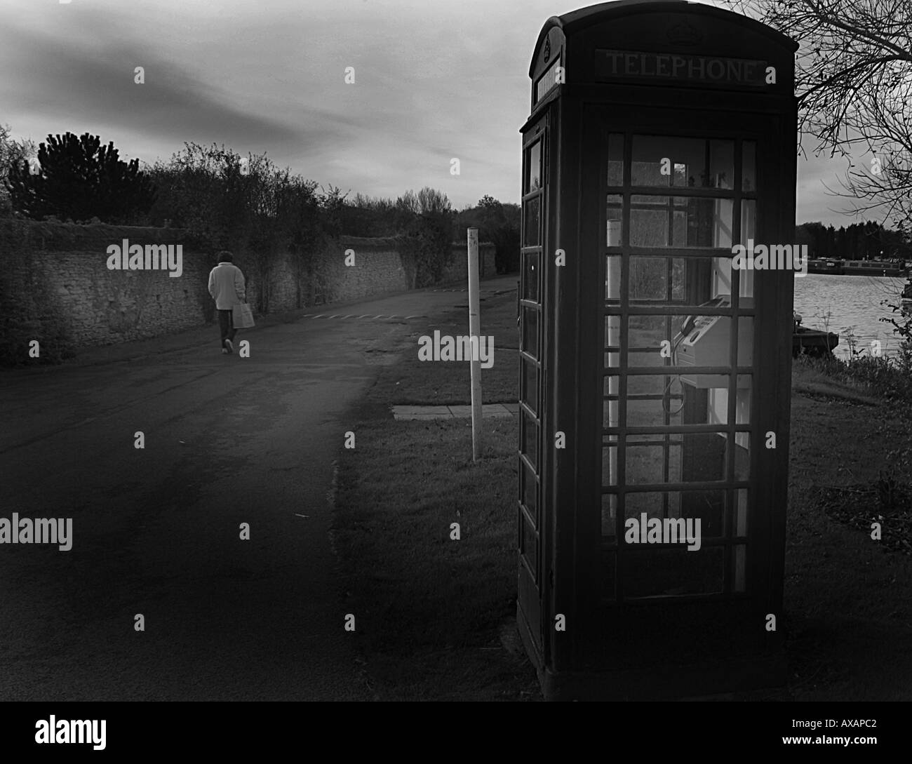 alte rote Telefonzelle an einem See in Großbritannien Stockfoto