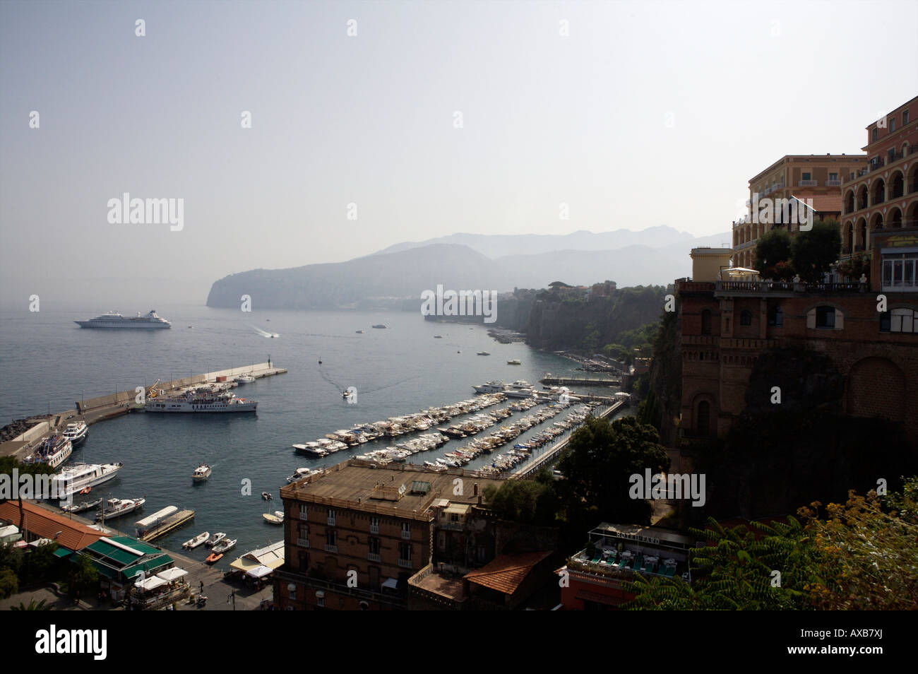 Ein Blick auf den Hafen von Sorrent mit einem Kreuzfahrtschiff in den Hintergrund und verschiedenen Hotels, Boote und Yachten im Vordergrund Stockfoto